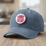 Pink pumpkin button with a bow and breast cancer awareness ribbon on a white background