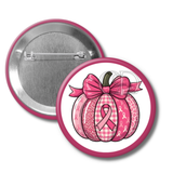 Pink pumpkin button with a bow and breast cancer awareness ribbon on a white background