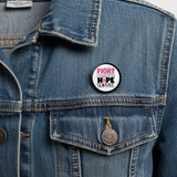 Pinback button with 'Fight Believe Hope Survive' text and pink ribbon on a jean jacket