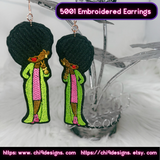 Pair of Afro Diva embroidered earrings in green and pink, hanging on a decorative stand.