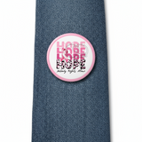Pinback button with 'Hope Nobody Fights Alone' text and pink ribbon design on a jean tie.