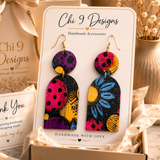 Blue Floral Wood Dangle Earrings displayed on a Chi 9 Designs jewelry card with luxury gift packaging.