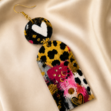 Colorful abstract earring on a beige fabric background
