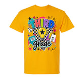 A bright yellow short-sleeve t-shirt with a colorful retro-style graphic on the chest reading 'THIRD grade' in bold multicolored letters, surrounded by doodles of stars, hearts, a lightbulb, a notebook, and other school-themed illustrations, shown on a plain white background.