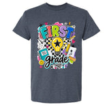 A dark heather gray t-shirt featuring a colorful 'First Grade' graphic print on the front, displayed against a solid white background.