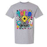 A gray short-sleeve crewneck t-shirt featuring a colorful graphic design on the front that reads 'THIRD grade' with school-themed doodles like a lightbulb, notebook, pencil, and stars.