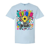 A light blue short-sleeve crewneck t-shirt featuring a colorful 'SEVENTH grade' graphic on the front, complete with a lightbulb, stars, hearts, and school-themed doodles, shown against a plain white background.