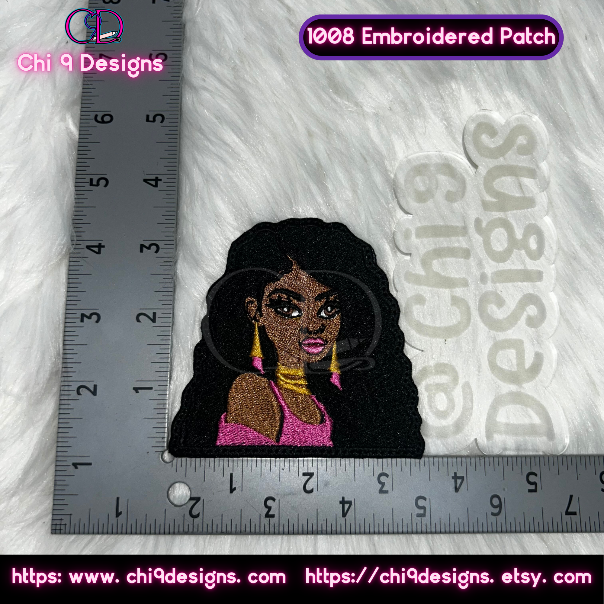 Close-up view of a single Fierce Diva embroidered patch, Style No. 1008, featuring a diva with jet black hair, gold earrings, and a bright pink outfit, shown next to a ruler to display its compact yet detailed size