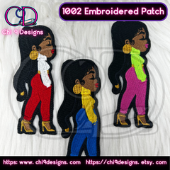 Three customizable embroidered Fashionista patches, Style No. 1002, featuring different outfit colors—red, blue, and pink—each with matching high heels, displayed on a white furry background.