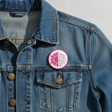Button badge with pink sunflower and breast cancer awareness ribbons on a  jean jacket