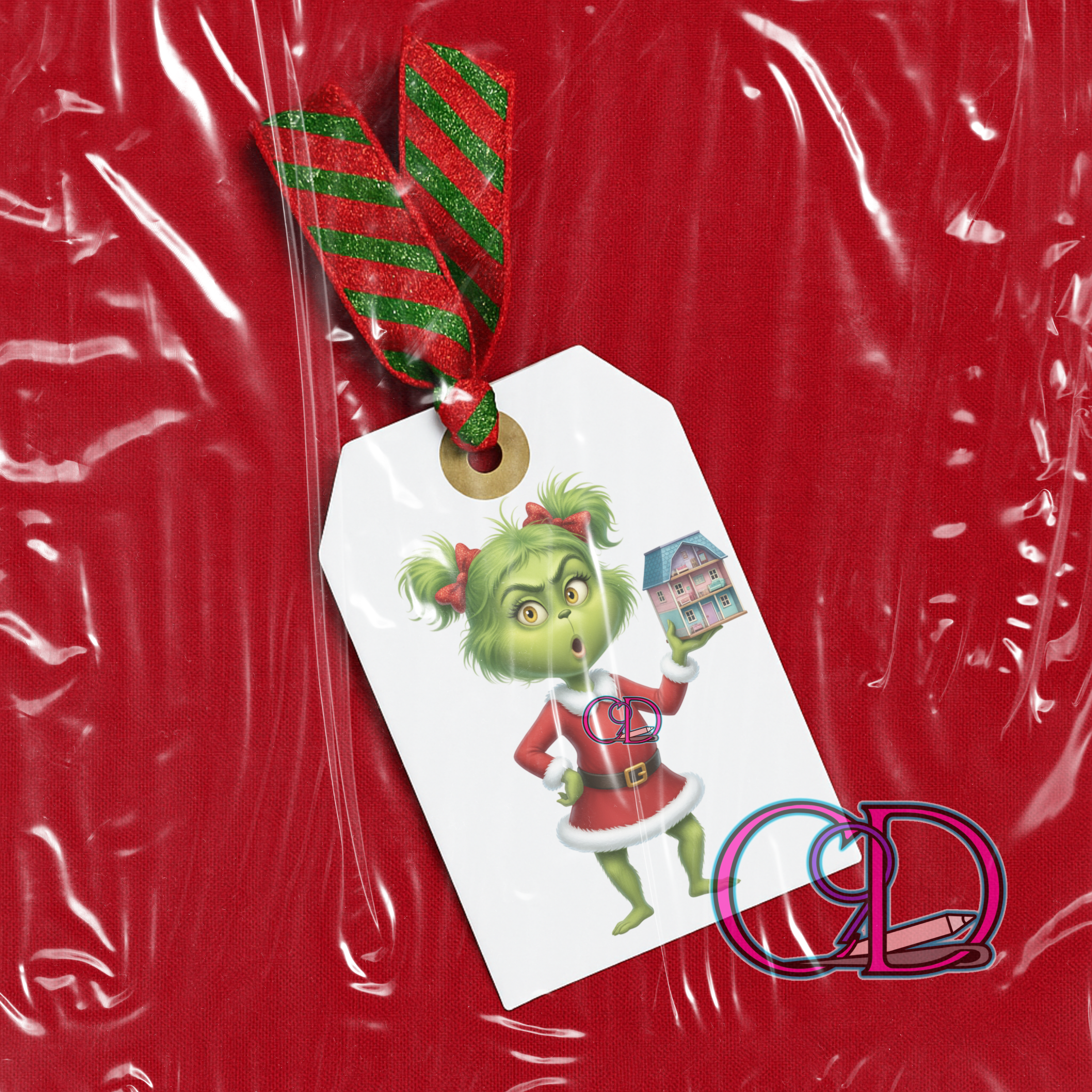 Gift tag with a green character holding a house, tied to red wrapping paper.