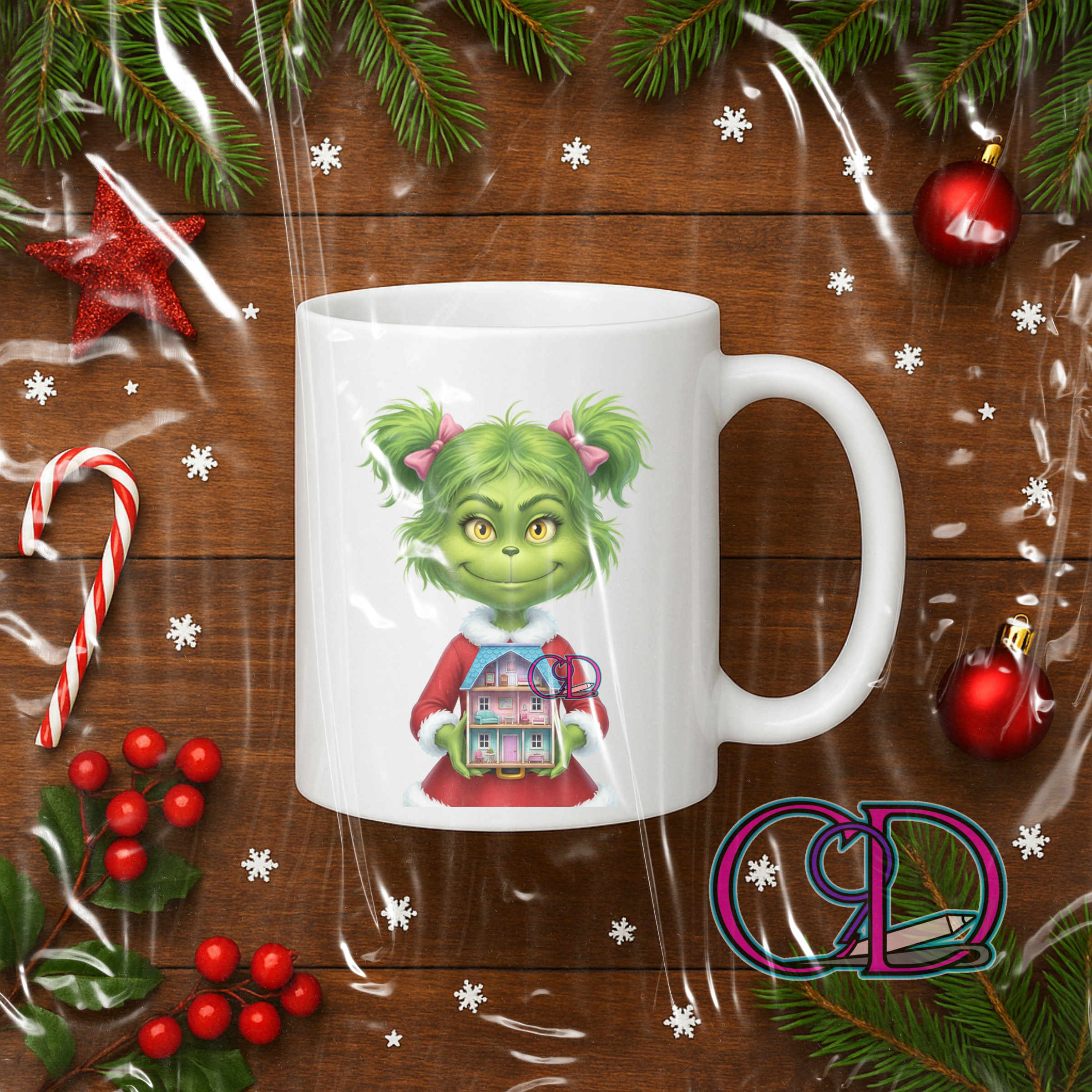 White mug with a green character design on a wooden surface with Christmas decorations.