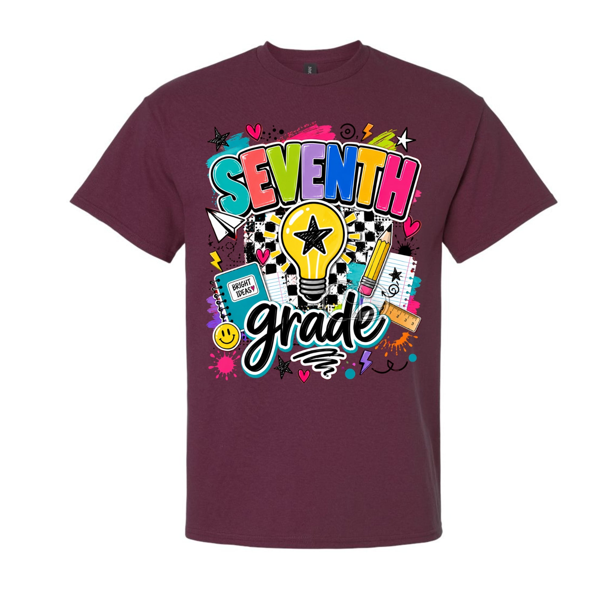 A maroon short-sleeve crewneck t-shirt featuring a colorful graphic design on the front that reads 'SEVENTH grade' with school-themed doodles like a lightbulb, pencil, notebook, and stars.