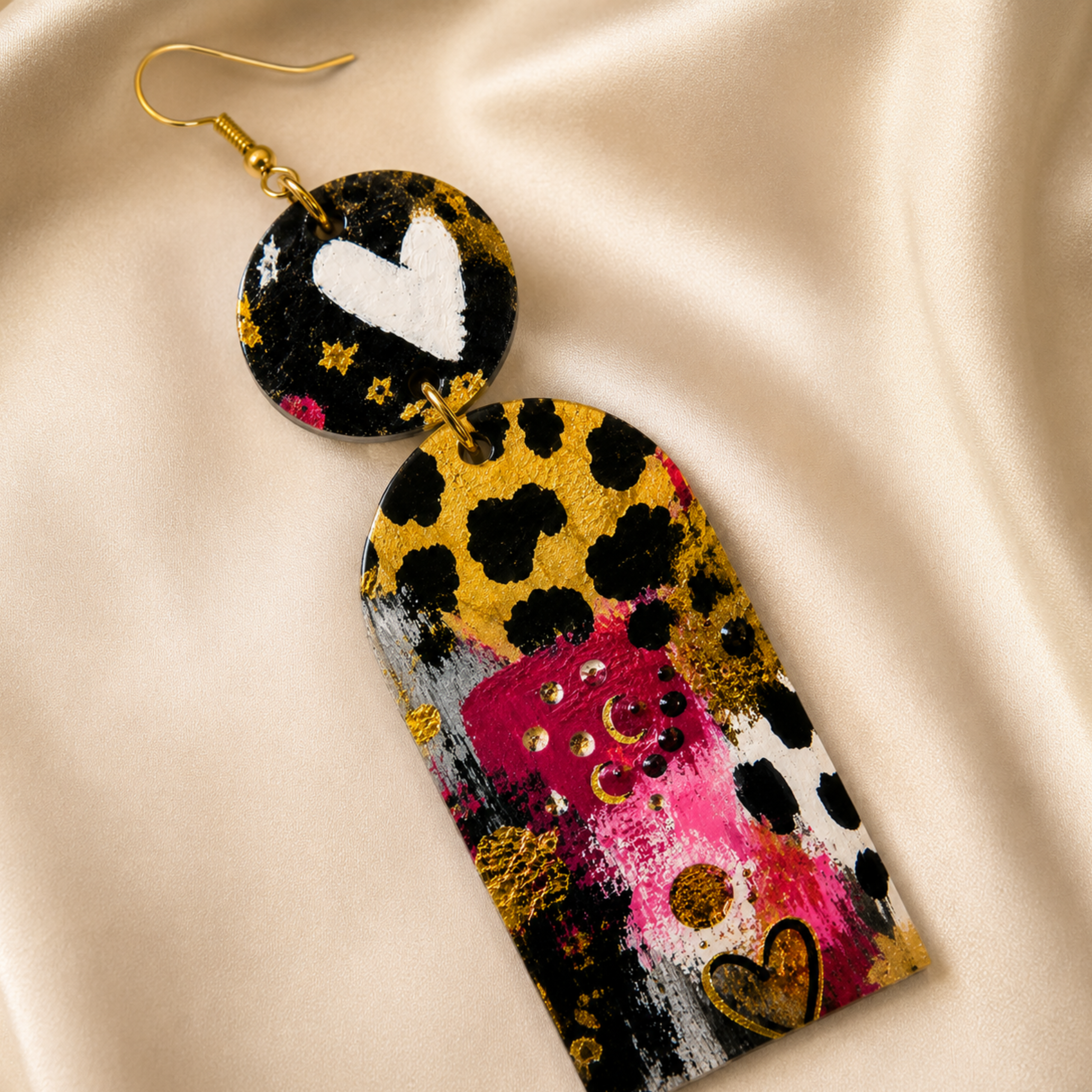 Colorful abstract earring on a beige fabric background