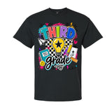 A black short-sleeve crewneck t-shirt featuring a colorful graphic design on the front. The graphic reads 'THIRD grade' in stylized bubble lettering, surrounded by school-themed doodles including a lightbulb, notebook, pencil, and heart icons, set against a plain white background.