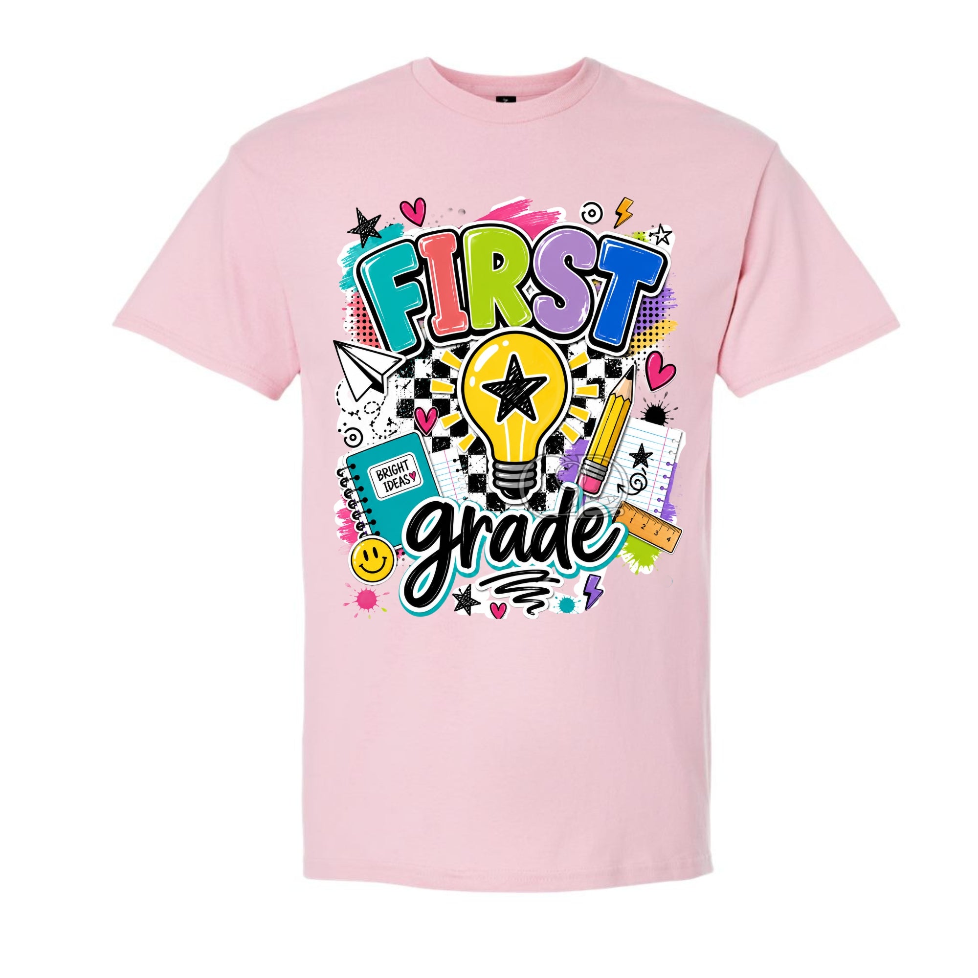A light pink short-sleeve t-shirt with a colorful 'FIRST grade' graphic on the front, featuring a light bulb, pencils, notebook, and stars.